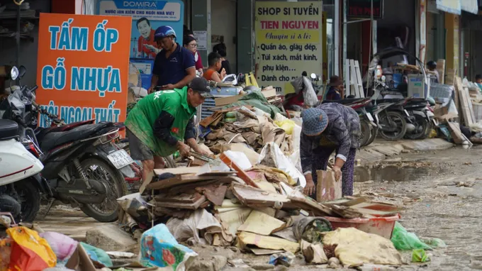 Người dân phường Tây Nha Trang (tỉnh Khánh Hòa) dọn dẹp rác tồn đọng sau trận lũ lịch sử. Ảnh: HIẾU GIANG